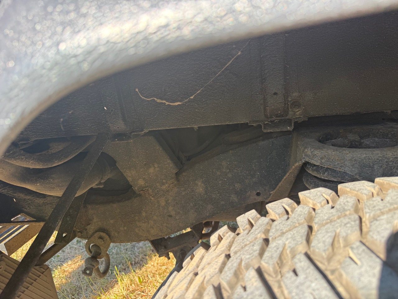 Close-up inside a rear wheel arch showing the chassis and suspension area