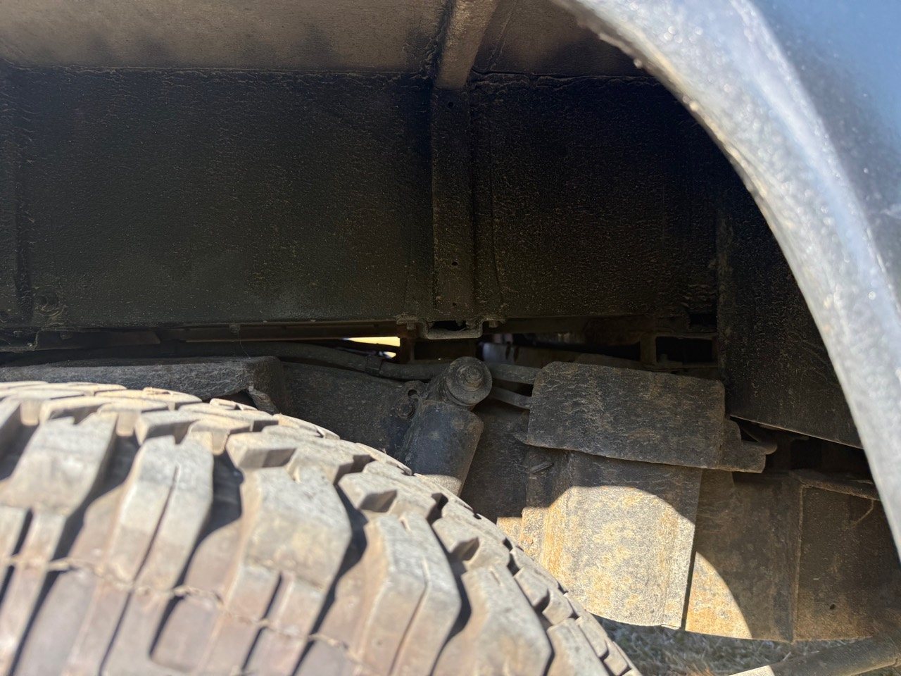 Close-up inside the opposite rear wheel arch showing suspension components