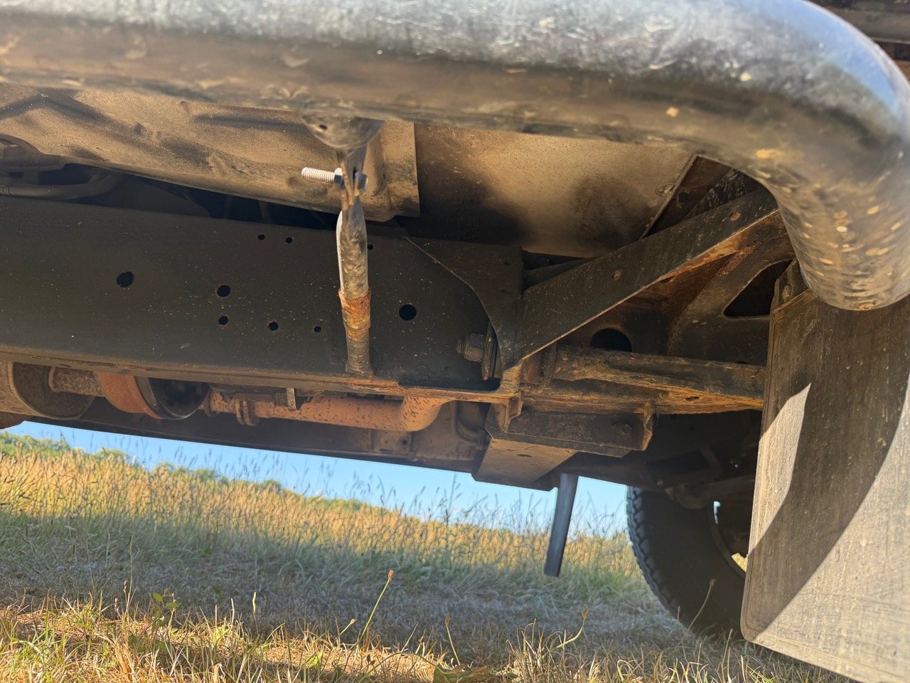 View beneath the rear of the Defender showing chassis, exhaust and suspension components