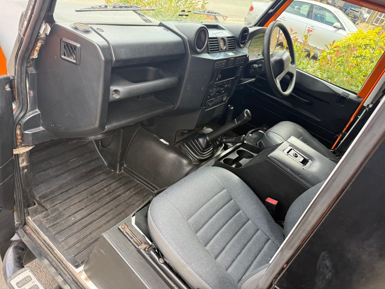 Wide view of the Defender's two-seat cab, dashboard and manual gear levers